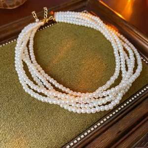 Elegante fünfreihige Perlenkette mit verstellbarem Goldverschluss auf Tablett