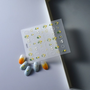 Close-up of 5D embossed nail art stickers featuring yellow tulips and white bows