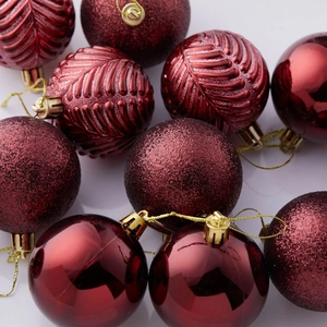 Set of red Christmas ball ornaments with glossy, matte glitter, and leaf textures