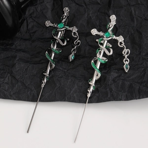 Macro detail of gothic snake cross hairpins in silver and gunmetal with green stones