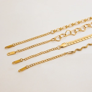 Detailed macro view of four gold-plated stainless steel chains with various link patterns