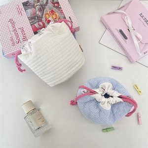 Close-up of quilted drawstring storage bags with floral lining and soft cotton texture
