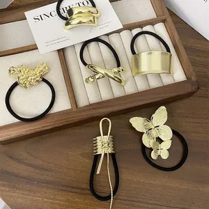Set of six gold punk-style metal hair ties with butterfly and lava textures on wood