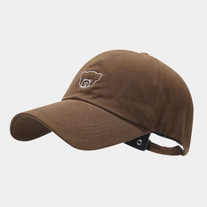 Detailed close-up of brown outdoor sports cap featuring white bear embroidery and cotton texture