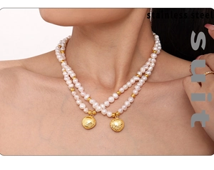 Close-up of double-layer natural pearl necklace with gold-plated pendants on a model