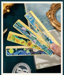Macro view of brass metal ruler bookmark featuring Van Gogh and Monet oil painting designs