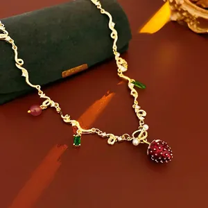 Chic strawberry pendant necklace with red glass beads and green crystal on gold chain