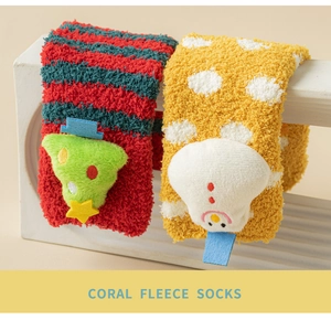 Close-up of thick coral fleece Christmas socks with plush 3D snowman and tree details