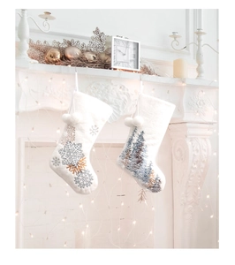 White plush Christmas stockings with snowflake and pine tree embroidery on fireplace