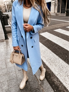 Street style shot of a light blue double-breasted wool coat with notch lapels on a model