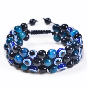 Macro shot of double-row evil eye beads and natural tiger eye stone with adjustable cord