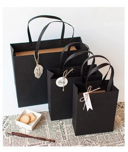Detailed comparison of three sizes of matte black gift bags with fabric handles