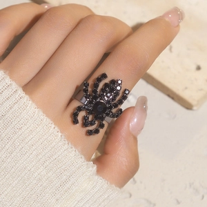 Close-up of a gothic black spider ring featuring encrusted crystals on a metal base