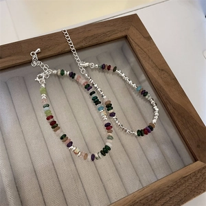 Colorful natural stone heart pearl bracelet with silver accents on a velvet tray