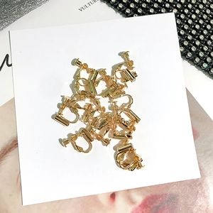 Detailed close-up of golden screw-back earring converters on a white display card
