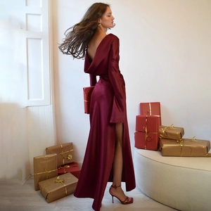 Detail of elegant burgundy satin dress featuring an open back and high side slit design