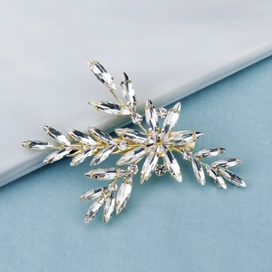 Close-up of golden leaf hair clip featuring marquise cut sparkling crystals