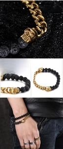 Macro detail of punk skull bracelet featuring black volcanic stone and gold steel links