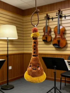 Detailed plush oboe musical instrument doll with bead chain in music studio
