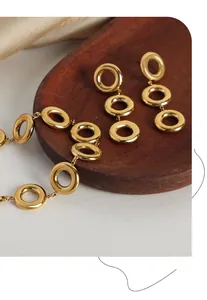 Detail of geometric gold-plated titanium steel jewelry set on wooden tray decoration