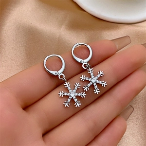 Elegant silver snowflake tassel earrings with sparkling crystals on silk background