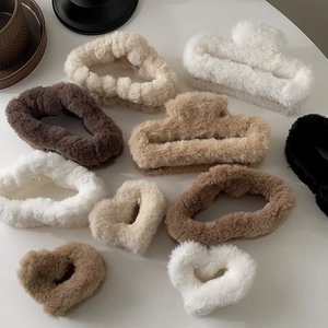 Detailed overhead view of assorted plush rectangle and heart claw clips in neutral tones