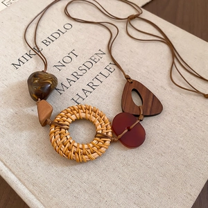Detailed view of bohemian necklace with resin, wood and woven rattan pendant textures