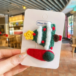 Gros plan de barrettes sapin de Noël au crochet et accessoires cheveux en peluche rouge