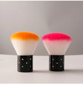 Detailed view of two gradient orange and pink makeup brushes with rhinestone base