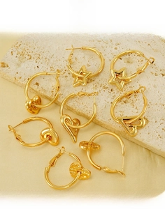 Detailed close-up of 18K gold-plated titanium steel hoop earrings with star and heart charms