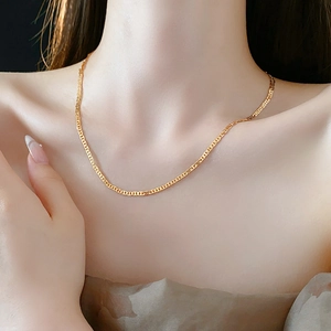 Close-up of a model wearing the delicate golden beaded necklace with Shoushan stone accents