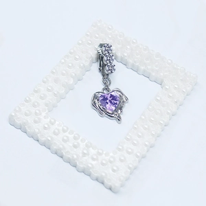 Détail de la boucle d'oreille cœur argenté avec ailes d'opale violette et oxydes blancs
