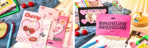Detail of pink Y2K retro postcards featuring cherry and puppy designs on denim