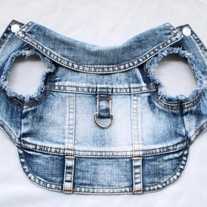 Blue washed denim pet vest with metal D-ring and frayed edges on white background