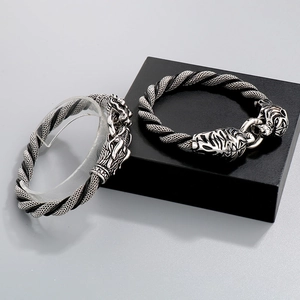 Detail of vintage titanium steel dragon and tiger head clasps on woven leather bracelets