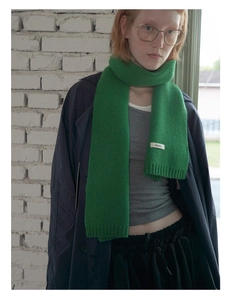 Detail of 100% Australian wool scarf in vibrant green with ribbed edges and wool label