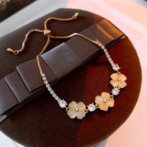 Macro detail of cat eye stone flower bracelet with golden zircon chain on velvet box