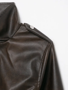 Dettaglio della spalla di una giacca in pelle marrone scuro con bottone metallico argento
