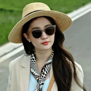 Outdoor street style shot of Y2K cycling sunglasses paired with a straw hat and silk scarf