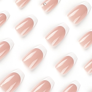 White French tip press-on nails with nude pink base and subtle rhinestone accents