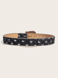 Detail of black rhinestone belt with chain trim and square metal buckle on beige background