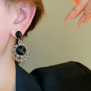 Macro detail of vintage style black gemstone earrings with sparkling crystal accents