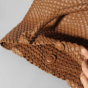 Brown leather woven tote bag featuring a magnetic snap closure and large interior capacity