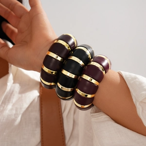 Detail of wide segmented acrylic bracelet featuring black, purple and red color blocks