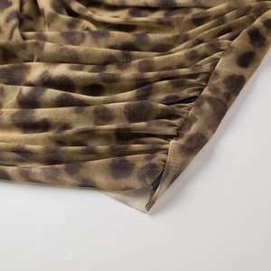 Macro detail of breathable leopard print mesh fabric with elegant gathered pleats