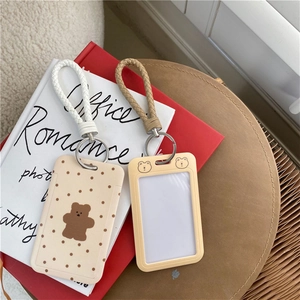 Detail of cute bear plush card holders with woven lanyards on decorative books