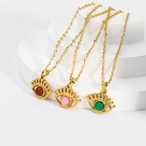 Detail view of gold eye pendant necklaces with red, pink and green round bead inlays