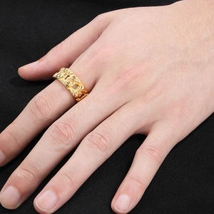 Close-up of a men's gold punk skull ring with embossed textures on a model's hand