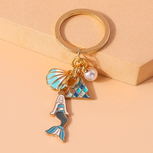 Detailed view of ocean themed keychain with blue shell, pearl and mermaid pendants