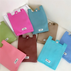 Flat lay of colorful knitted mini phone bags with button closures in various bright colors